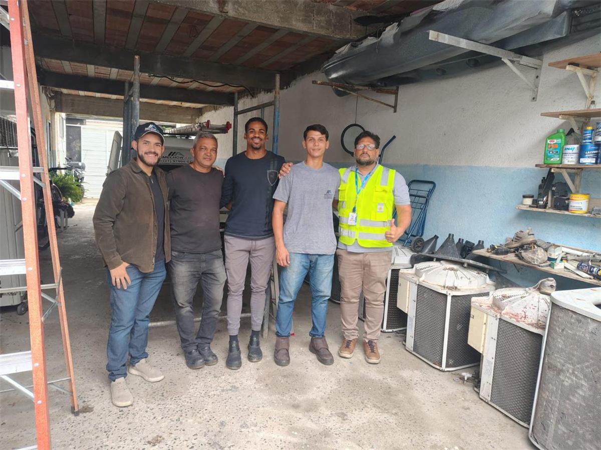 Equipe da MelhorAr reunida na base, com equipamentos de ar-condicionado ao fundo